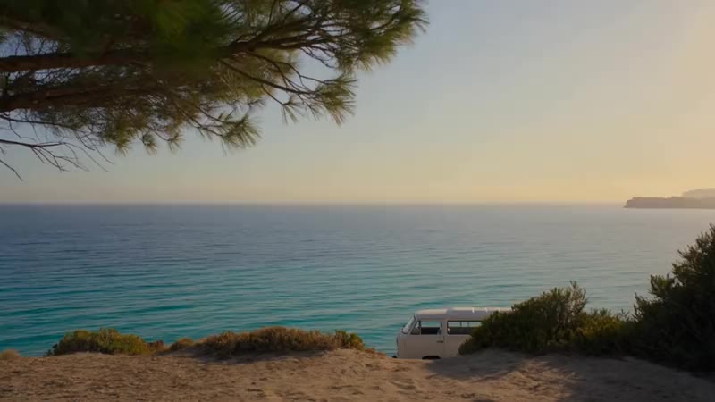 Furgone camper tra i pini sopra una scogliera sul mare al tramonto